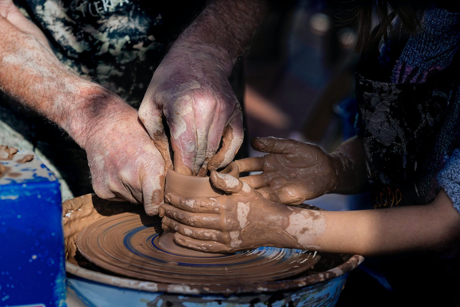 person making clay pot with clay